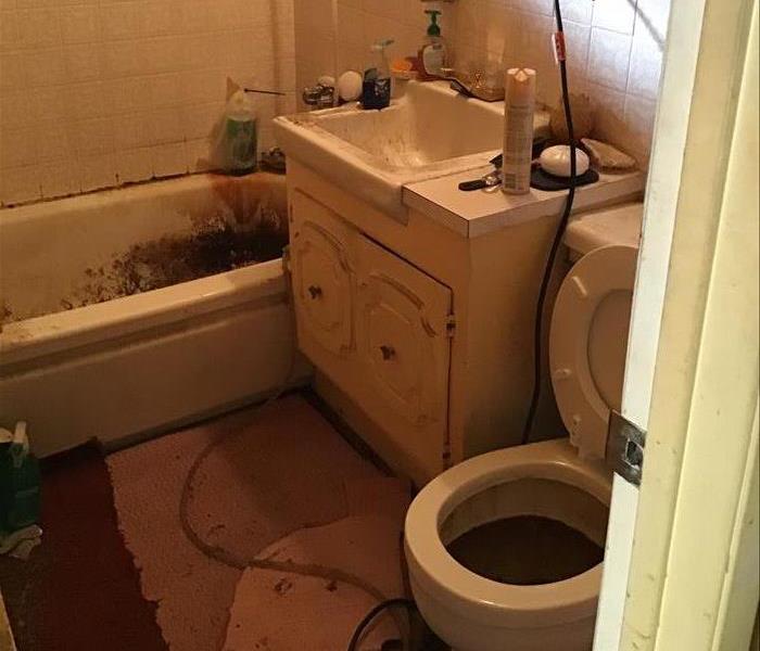 Bathroom with tub, toilet and single sink vanity.
