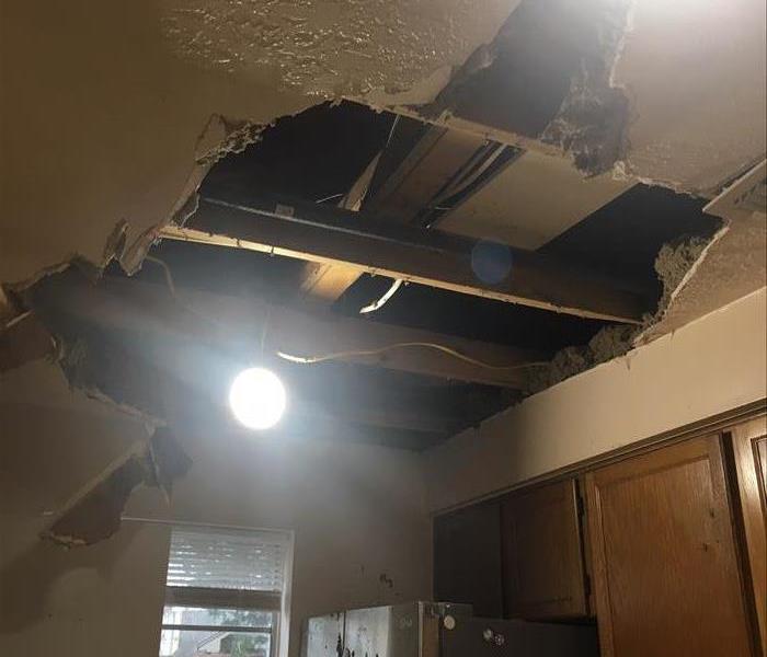 Ceiling in kitchen with debris falling out.