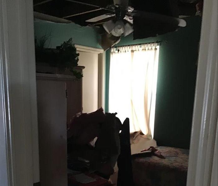 Bedroom with ceiling caved in from water damage